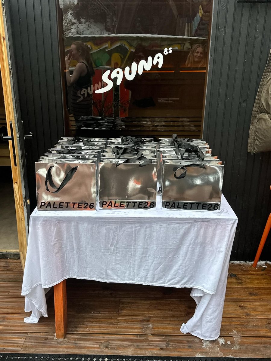 Mirrored Palette26 gift bags lined up on a table outside the Sauna85 entrance